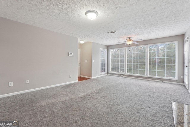 carpeted empty room with a textured ceiling and ceiling fan