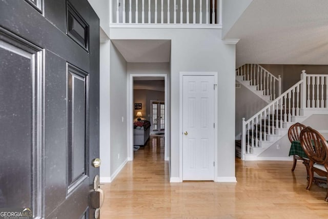 entryway featuring a towering ceiling and hardwood / wood-style flooring