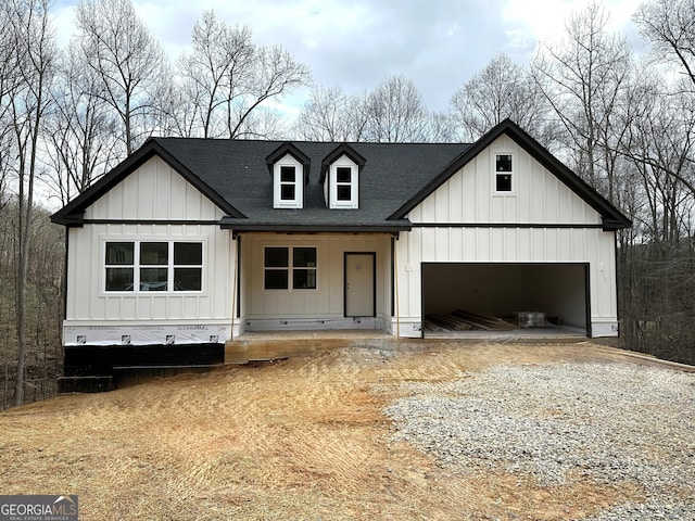 modern farmhouse style home featuring a shingled roof, driveway, board and batten siding, and an attached garage