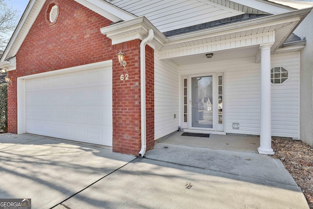 doorway to property with a garage and covered porch