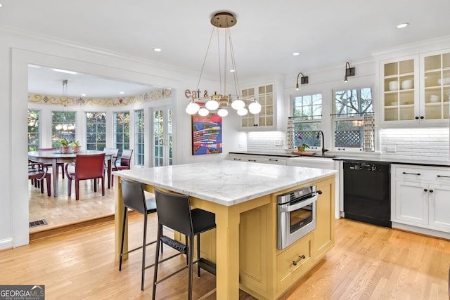 kitchen with a kitchen island, white cabinetry, black dishwasher, and oven