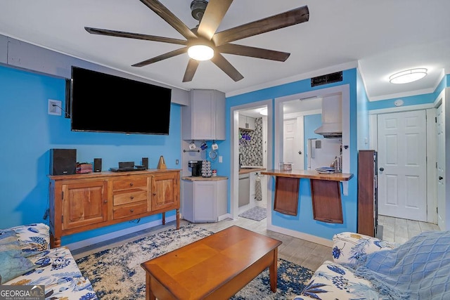 living room featuring ornamental molding, ceiling fan, and light hardwood / wood-style floors