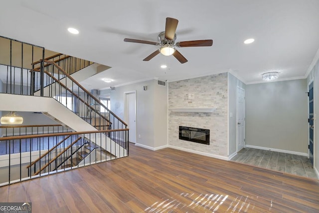 unfurnished living room with a fireplace, hardwood / wood-style floors, ceiling fan, and ornamental molding