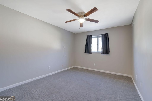 carpeted spare room with ceiling fan