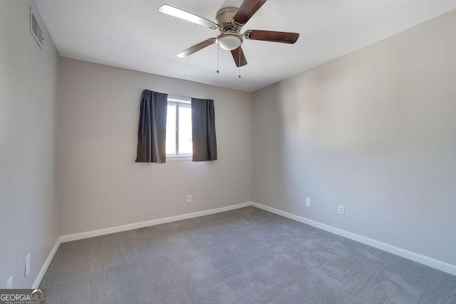 spare room with ceiling fan and carpet