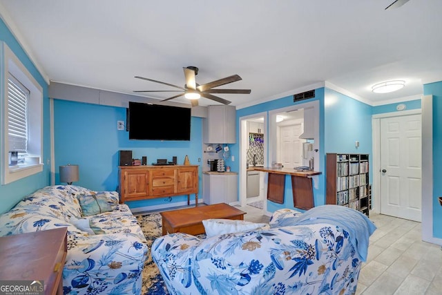 living room featuring ceiling fan, crown molding, and light hardwood / wood-style flooring