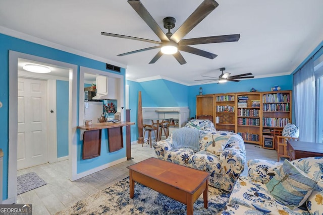 living room featuring ornamental molding, ceiling fan, and light hardwood / wood-style flooring