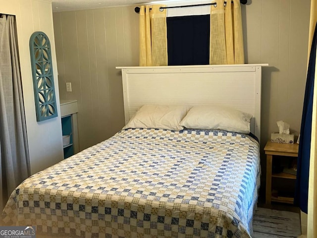 bedroom featuring wood walls