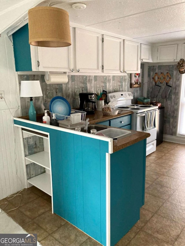 kitchen featuring white cabinets, white electric stove, and wooden walls