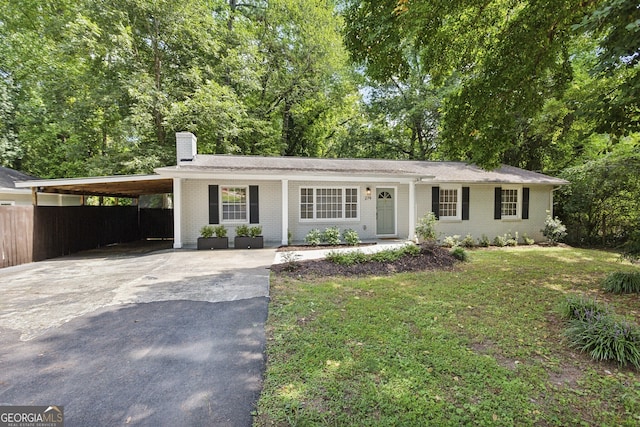 ranch-style house with a front yard and a carport