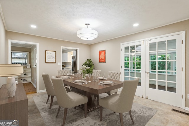 dining room with a textured ceiling and crown molding