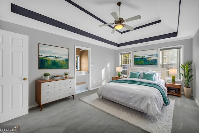 bedroom featuring ensuite bathroom, a raised ceiling, ceiling fan, crown molding, and light colored carpet