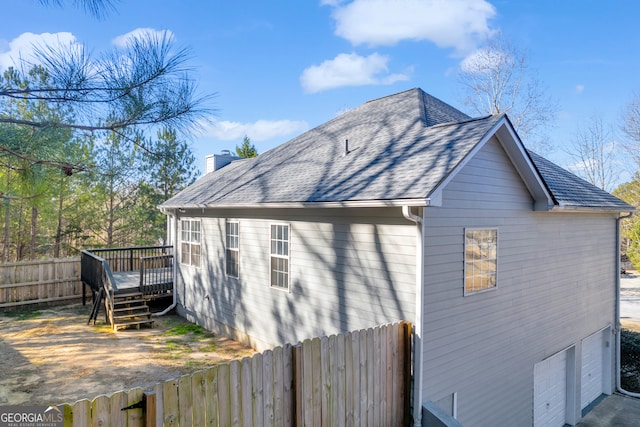 view of side of property featuring a garage and a wooden deck