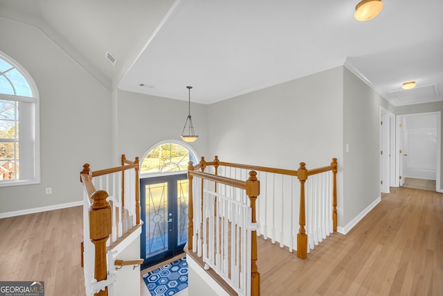 foyer with ornamental molding, light wood-type flooring, and lofted ceiling