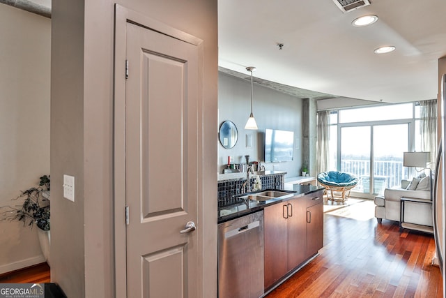 kitchen featuring dishwasher, a wall of windows, pendant lighting, dark hardwood / wood-style floors, and sink