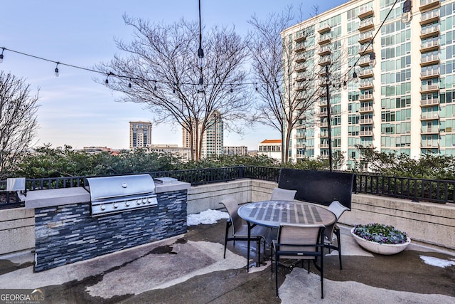 view of patio with exterior kitchen and a grill