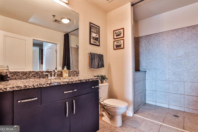 bathroom featuring walk in shower, tile patterned flooring, vanity, and toilet