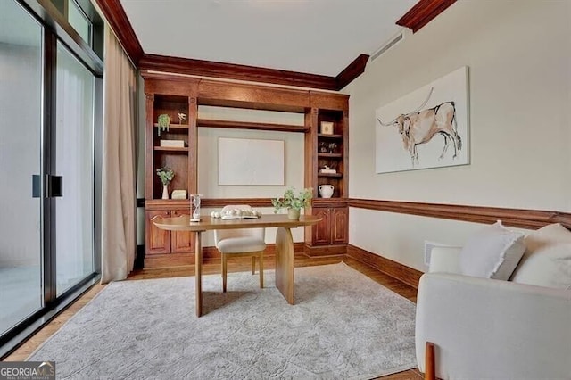 home office with light hardwood / wood-style floors and crown molding