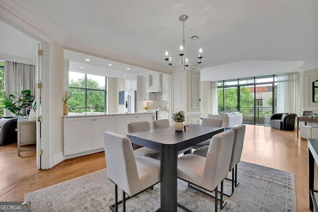 dining space featuring light wood-type flooring and a chandelier