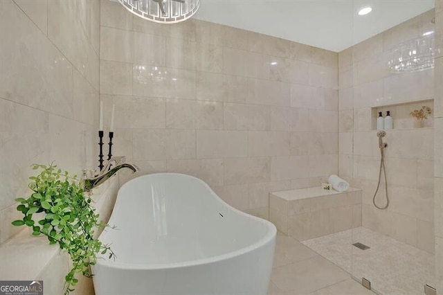 bathroom with tile patterned flooring, tile walls, and independent shower and bath