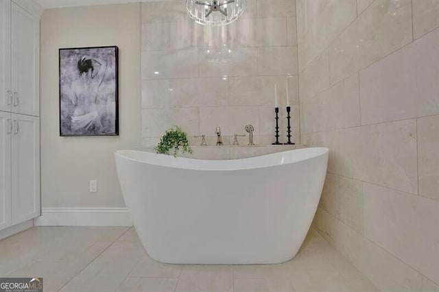 bathroom featuring tile walls, tile patterned flooring, and a tub to relax in