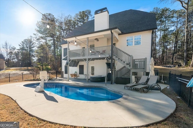 back of house featuring a jacuzzi, a chimney, a fenced backyard, stairs, and a patio area