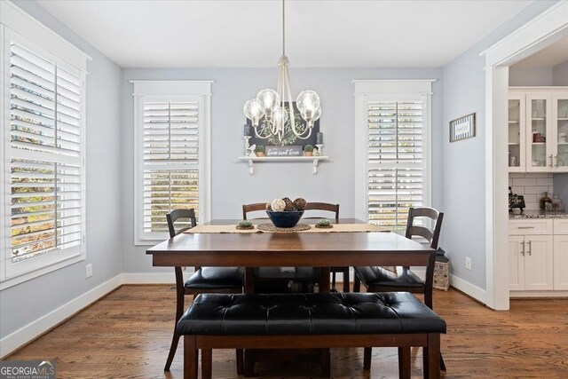 dining area with hardwood / wood-style flooring and a notable chandelier