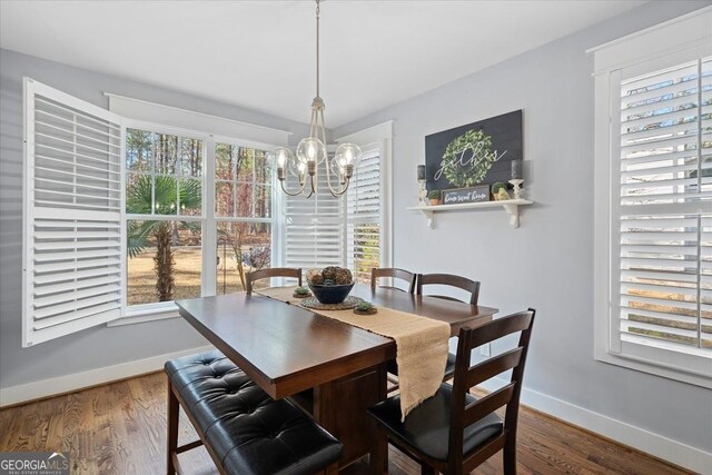 dining space with a notable chandelier and light hardwood / wood-style floors