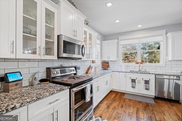 interior space featuring light stone counters, gray cabinetry, a breakfast bar, and pendant lighting