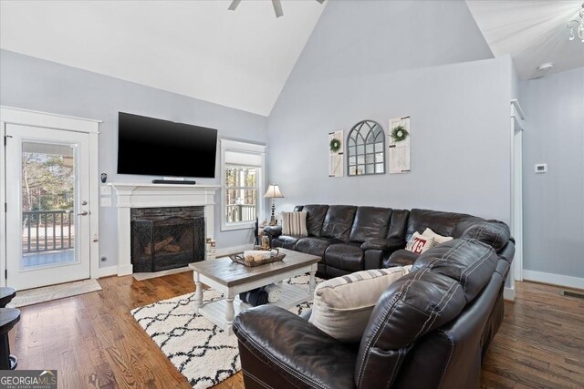 living room with a high ceiling and dark wood-type flooring