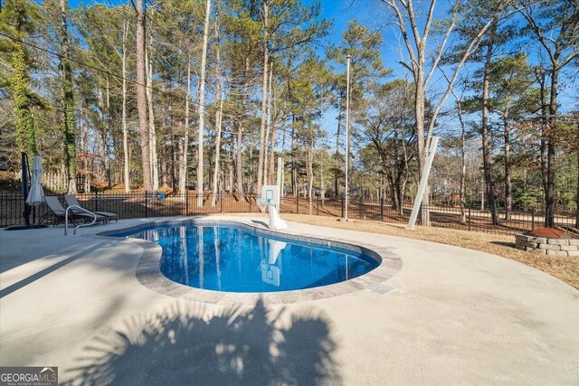 rear view of property with a balcony, a fenced in pool, and a patio