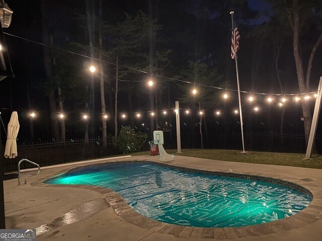 pool at twilight featuring a patio area