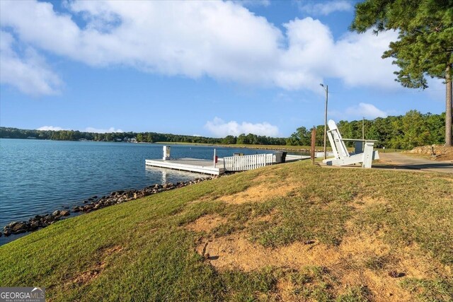 view of dock featuring a water view and a lawn