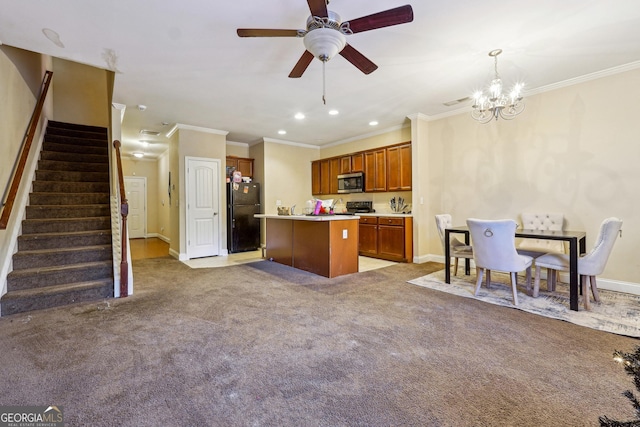 kitchen with ceiling fan with notable chandelier, black refrigerator, a center island, and ornamental molding