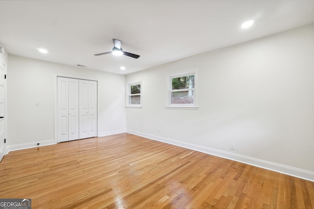 unfurnished bedroom with ceiling fan, a closet, and light hardwood / wood-style floors