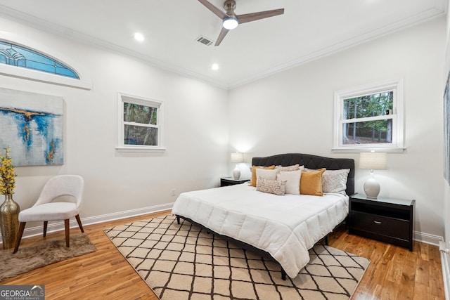 bedroom featuring ceiling fan, light hardwood / wood-style floors, and ornamental molding