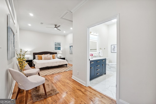 bedroom featuring ceiling fan, sink, connected bathroom, and ornamental molding