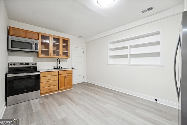 kitchen featuring light wood-type flooring, appliances with stainless steel finishes, and sink