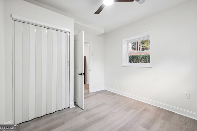 unfurnished bedroom featuring ceiling fan, a closet, and light hardwood / wood-style flooring