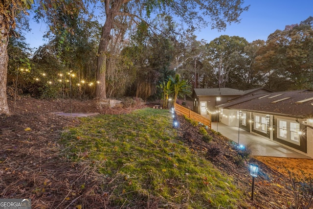 yard at dusk featuring a patio area