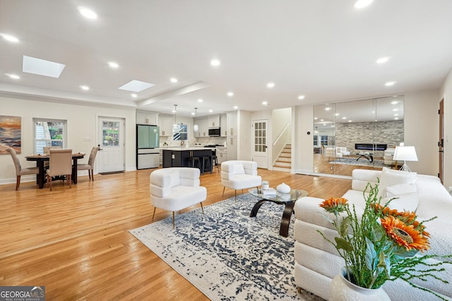 living room featuring a skylight and light hardwood / wood-style floors