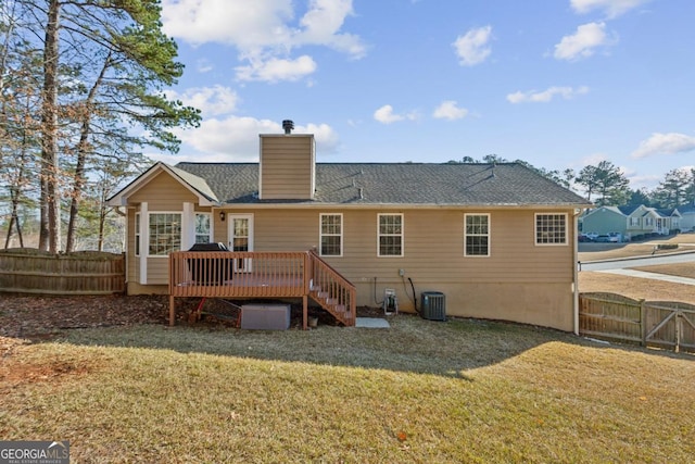 back of property with a lawn, central AC unit, and a wooden deck