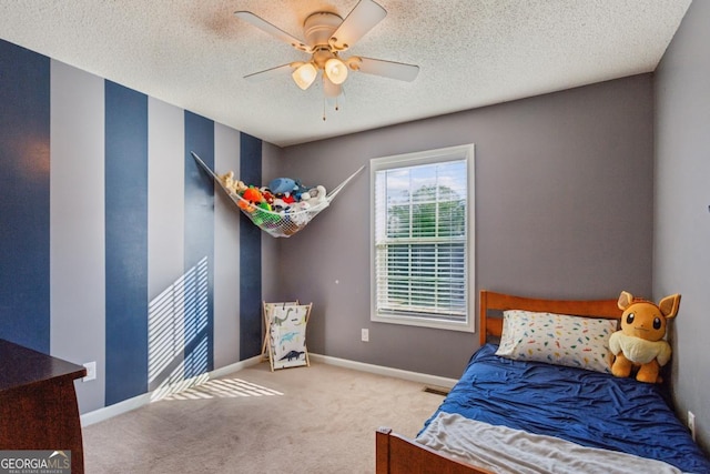 bedroom featuring ceiling fan, light carpet, and a textured ceiling