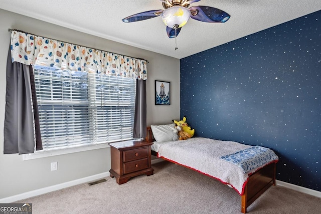 bedroom featuring a textured ceiling, ceiling fan, and carpet