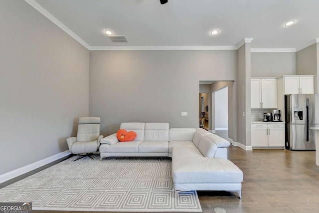 living room featuring ornamental molding and light hardwood / wood-style floors