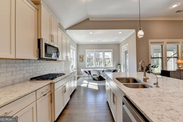 kitchen featuring vaulted ceiling, stainless steel appliances, decorative backsplash, sink, and decorative light fixtures