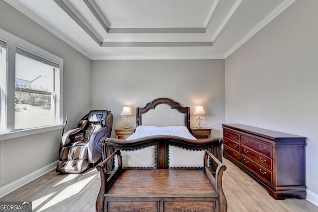 bedroom with a tray ceiling, crown molding, and light hardwood / wood-style floors