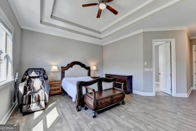 bedroom with multiple windows, ceiling fan, a tray ceiling, and ornamental molding