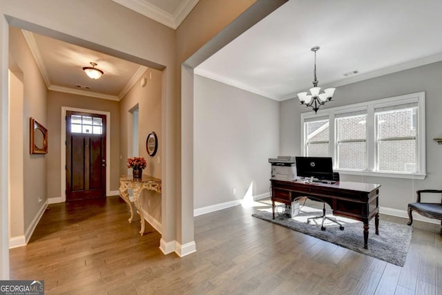 foyer with wood-type flooring, ornamental molding, and a notable chandelier