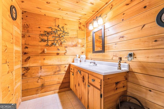 bathroom featuring tile patterned flooring, wood walls, wooden ceiling, and vanity